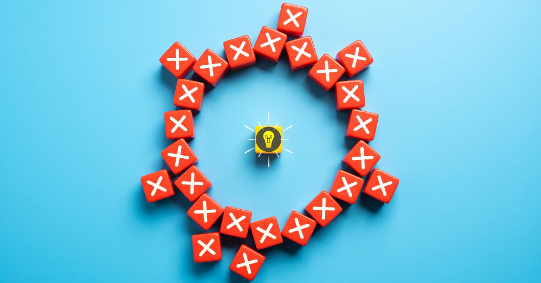 An idea bulb wooden dice surrounded by a circle of multiple wrong symbol red wooden blocks