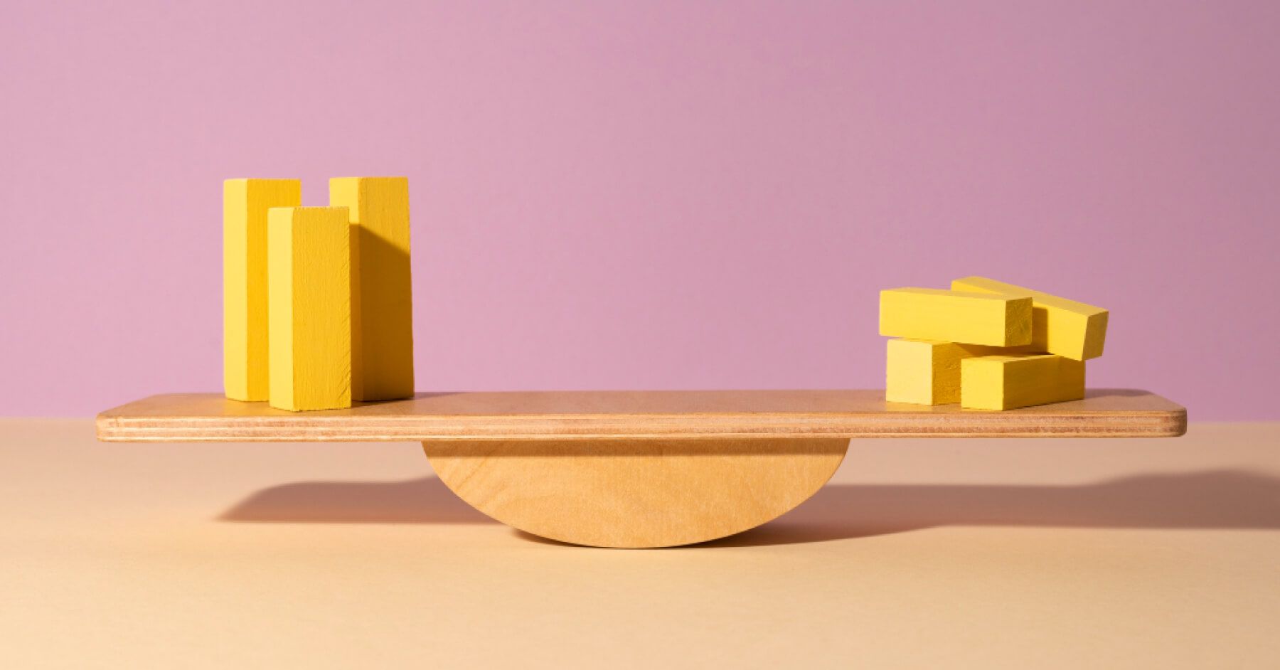Blocks of yellow wood standing and blocks of yellow wood flat against a balancing middle point