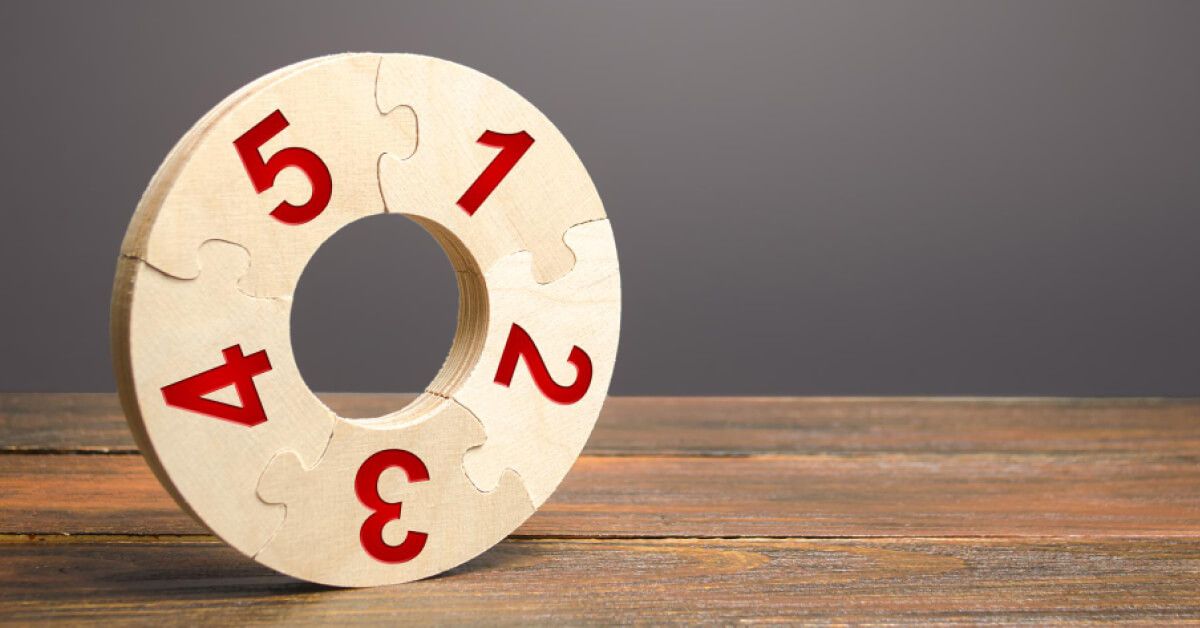 a round wooden puzzle with numbers on it