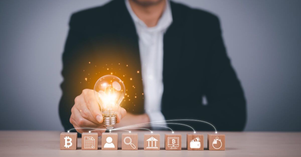 Wooden blocks of bank related things being connected through a bulb held by a man