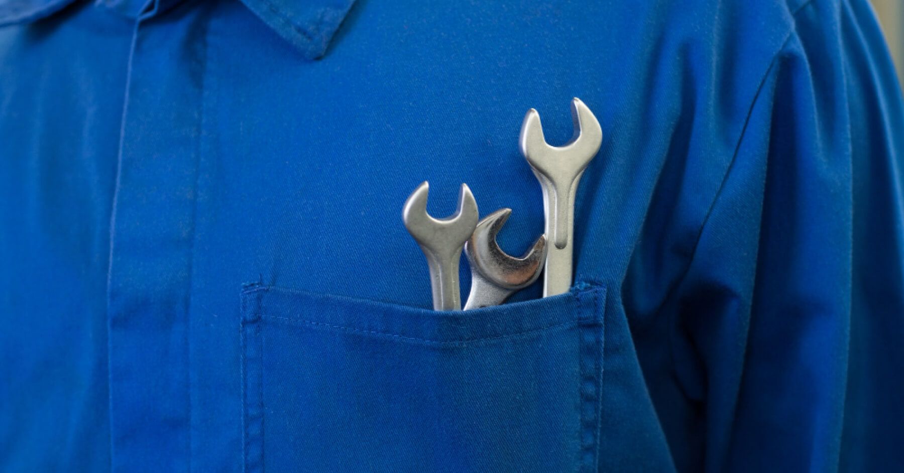 Blue shirt wearing man having manufacturing tools in his shirt chest pocket