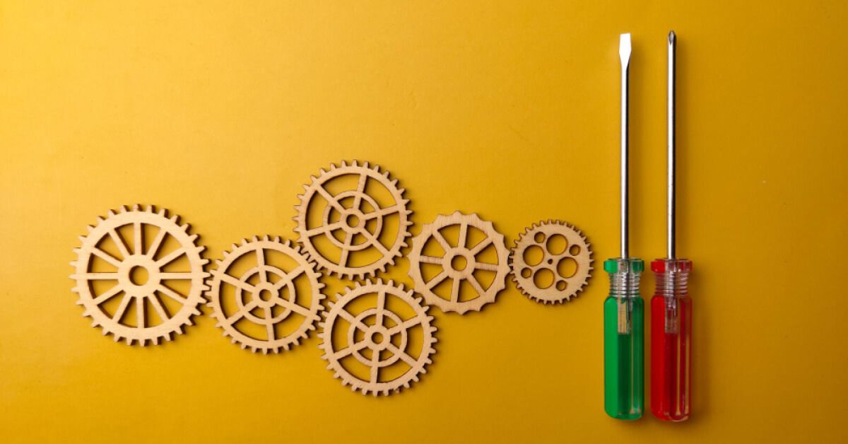 Screwdrivers of red and green next to wooden gears
