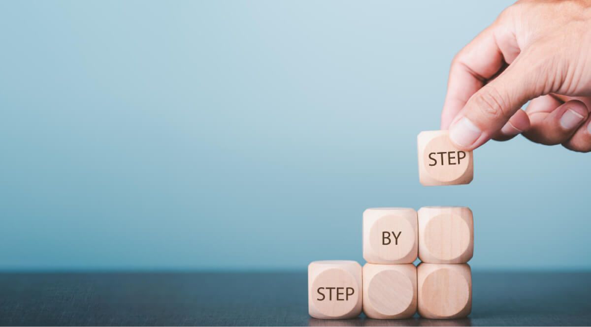 wooden blocks with Step by step written on them 