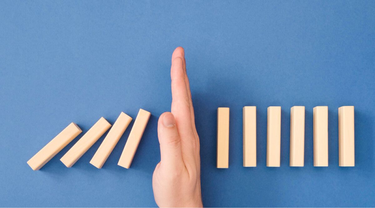 jenga blocks in a line blocked by a hand