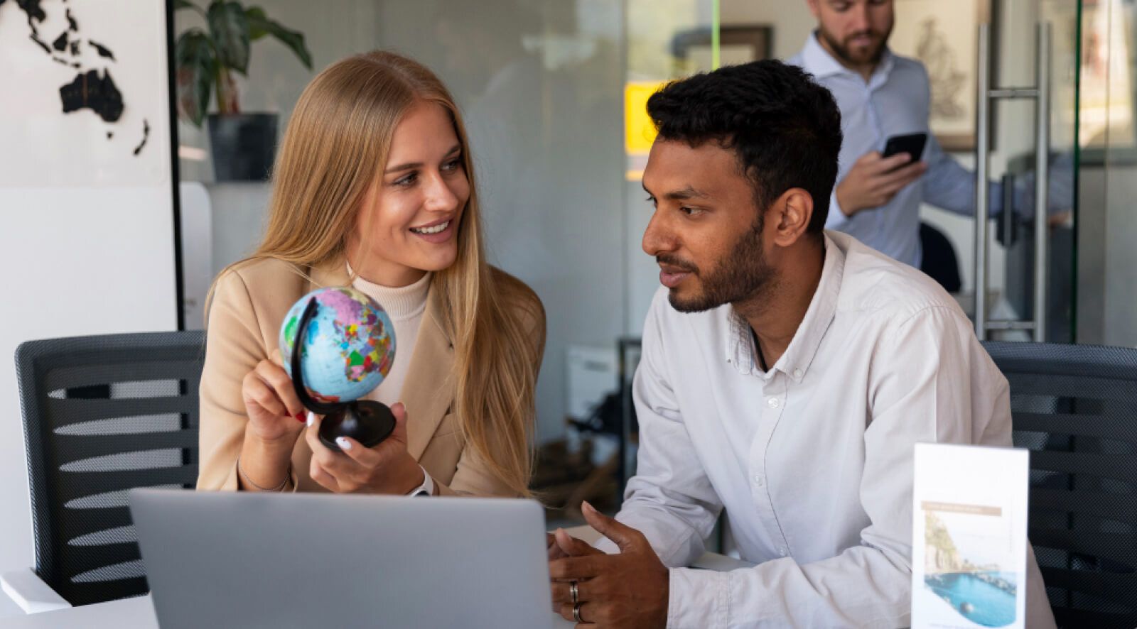 Two team members with one hold a globe