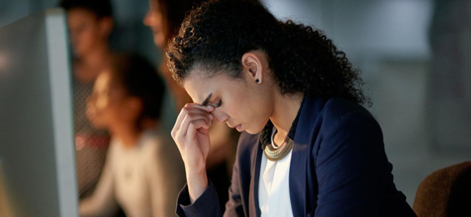 Stressed bank employee with her hand on her nose