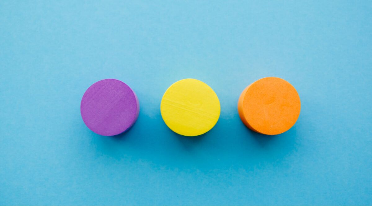 Three wooden blocks of various colours placed next to each other