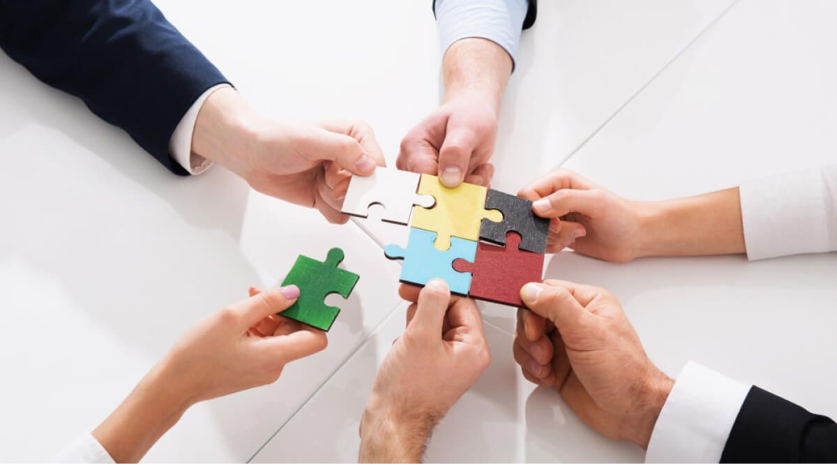 Multiple hands holding out puzzle pieces