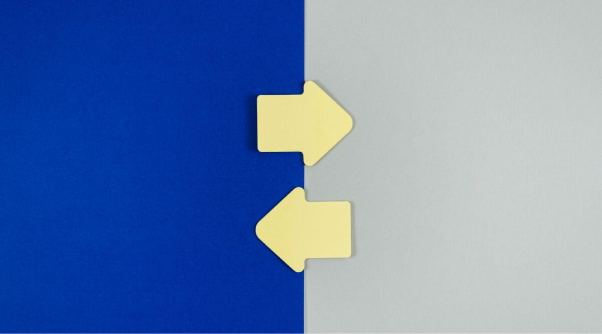 Two arrows of same colour crossing paths against different background colours