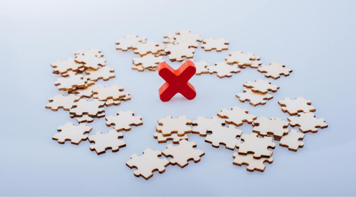 A red wrong symbol amongst puzzle pieces