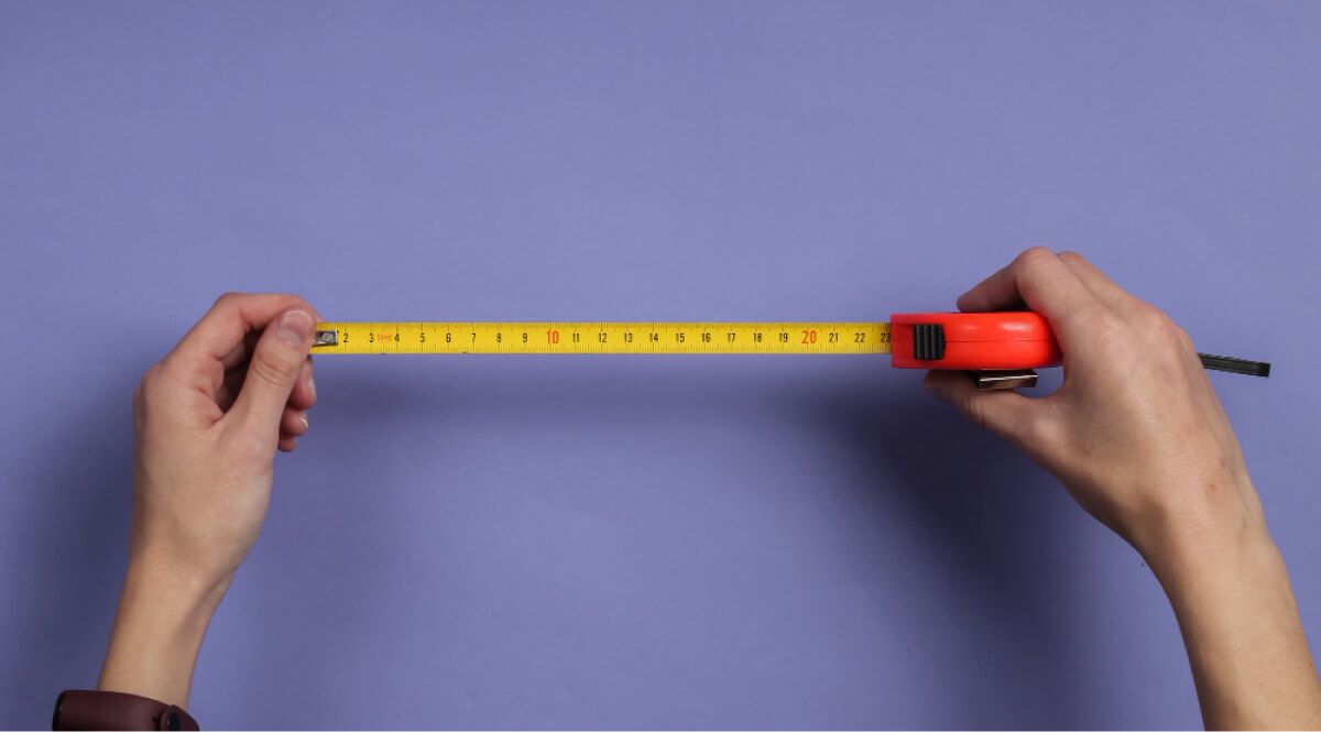 a hand opening a measuring tape