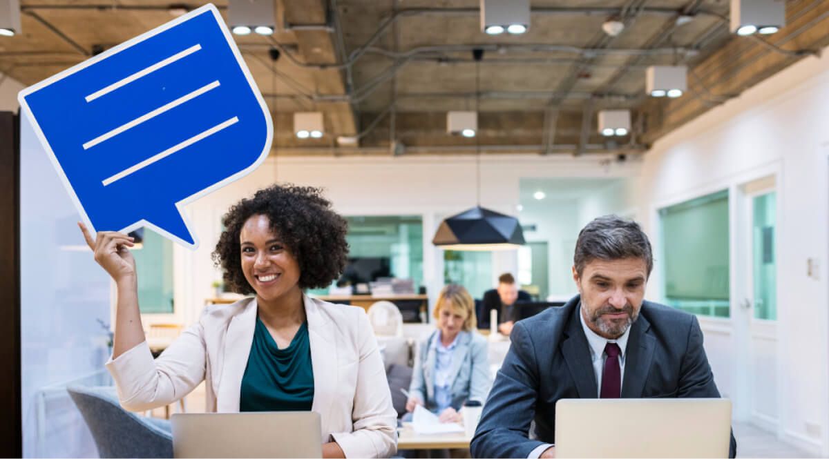 2 employees, one raising a message card