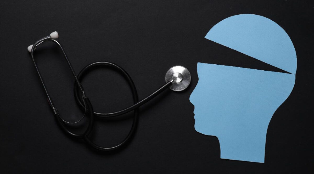 Paper cut mockup of a head cut and a stethoscope next to it