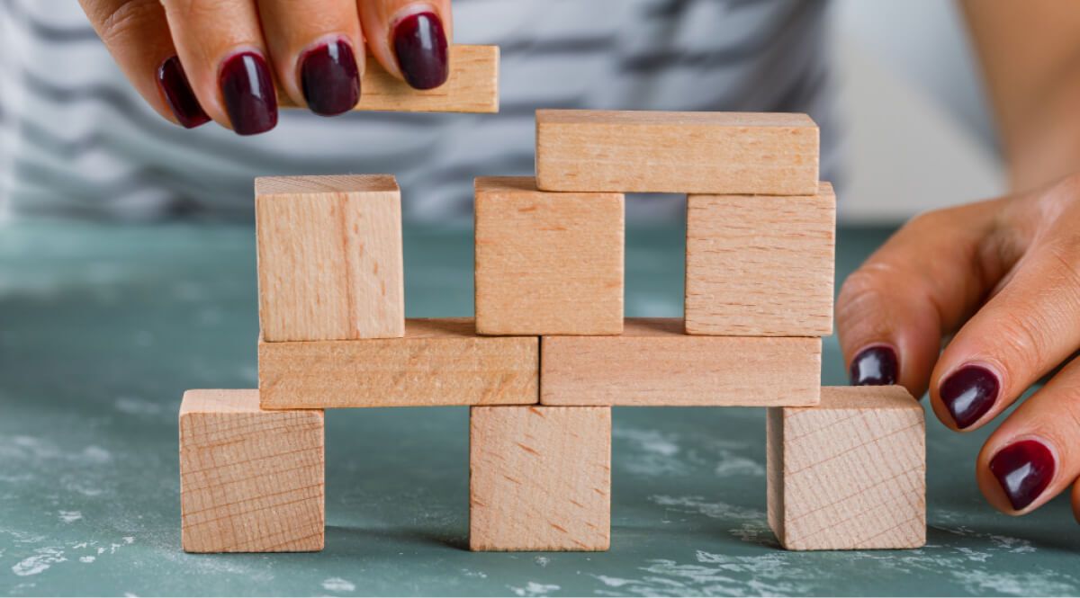 A person stacking up Wooden blocks 