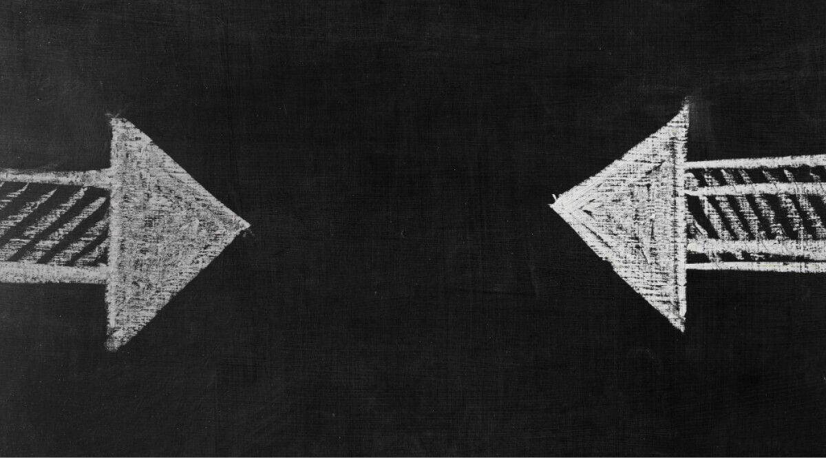 Two arrows drawn in chalk against each other