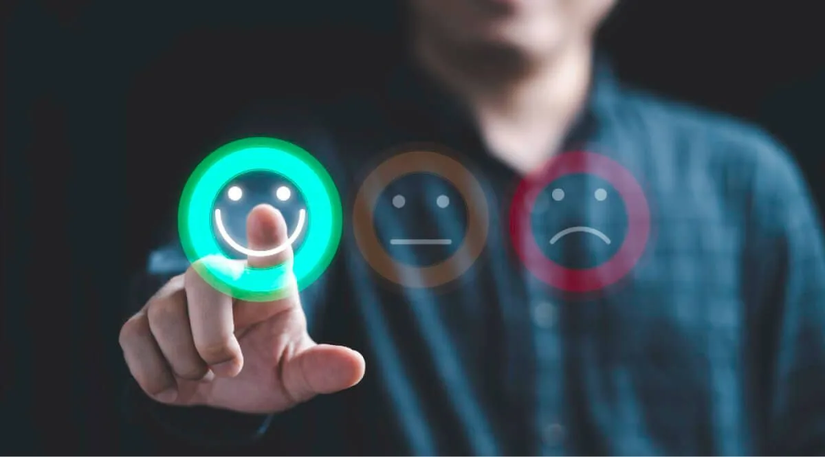 Man touching a happy emoji in screen amongst satisfied and bad emojis