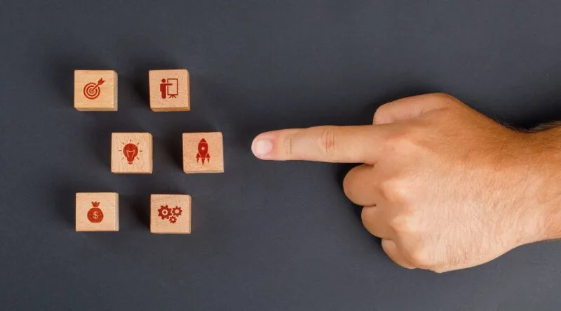 Hand pointing to wooden blocks of drawings