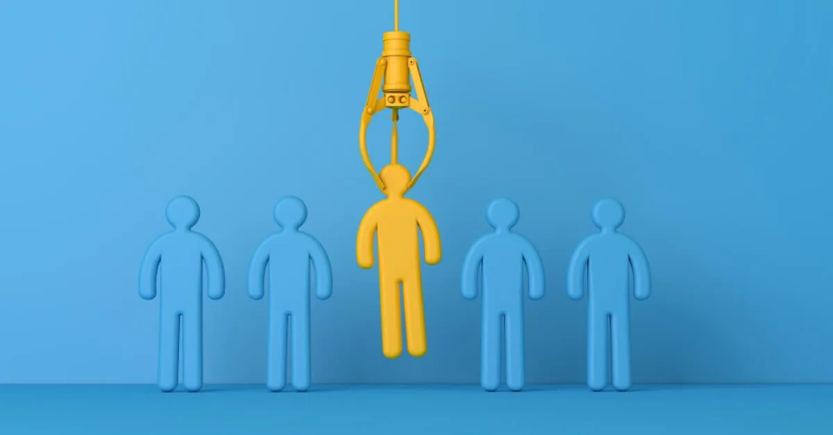 A crane claw picking a yellow figurine from a series of blue ones